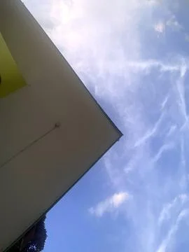 Dynamic Low Angle View of Roof Corner Against Blue Sky Stock Photos