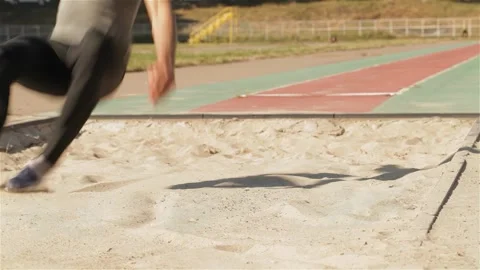 Dynamic male athlete soaring through the air in a long jump at the stadium Stock Footage 311542829
