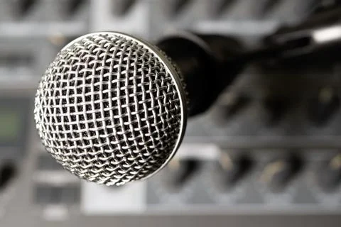 Dynamic microphone against the background of a musical synthesizer. Blurred b Stock Photos