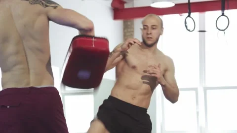 Dynamic muay thai fighter executing powerful kicks with coach's guidance Stock Footage 311544766