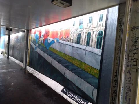 A dynamic mural on the Berlin Wall showing a person jumping Фото