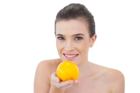Dynamic natural brown haired model offering an orange Stock Photos