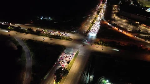 Dynamic Night Aerial View of a Bustling City Intersection with Vivid Traffic Stock Footage 320066486