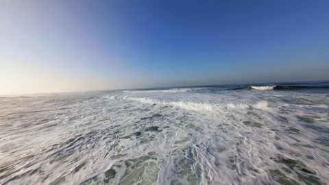 Dynamic ocean surface with foamy waves under blue sky 库存影片 346168653