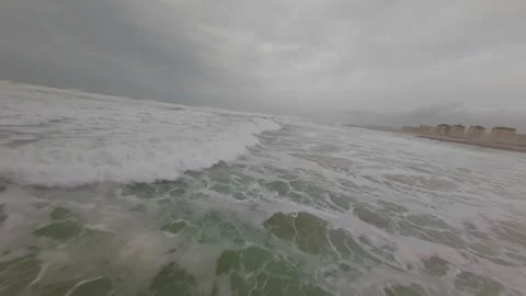 Dynamic ocean view with foamy surf rolling toward beachfront Stock Footage 345050983
