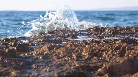 Dynamic ocean wave splashing over rough coastal rock formations outdoors Stock Footage 337409500