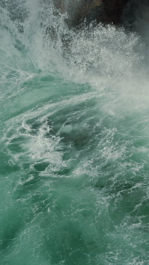 Dynamic Ocean Waves Aggressively Crashing Against the Rugged Rocky Shoreline Stock Footage 303869707