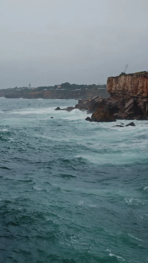 Dynamic Ocean Waves Aggressively Crashing Against the Rugged Rocky Shoreline Video stock 327789950