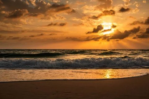 Dynamic Ocean Waves and Golden Hour Sunset on a Tropical Beach Stock Photos