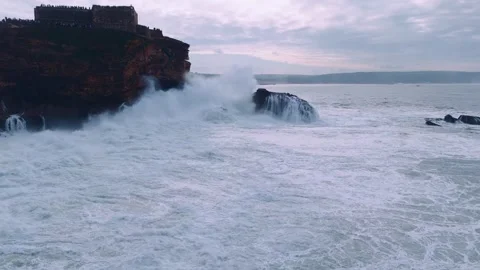 Dynamic Ocean Waves Crash Against the Rugged Rocky Coastline Video stock 296696514