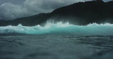 Dynamic Ocean Waves Crashing Against Dark Rocky Shoreline in 4K Stock Footage 323838228