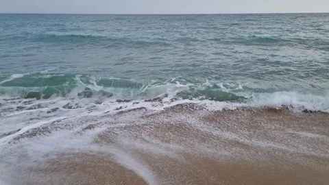 Dynamic ocean waves crashing onto sandy beach in rhythmic motion Stock Footage 321651135