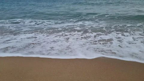 Dynamic ocean waves crashing onto sandy beach in rhythmic motion Stock Footage 321651137