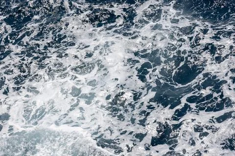 Dynamic ocean waves creating intricate white foam patterns on the surface Stock Photos
