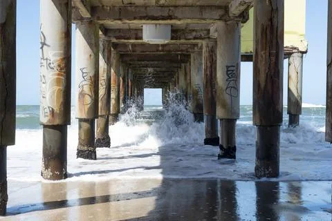Dynamic ocean waves flowing under the sturdy pier Foto stock