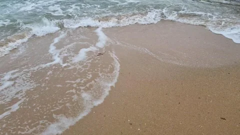 Dynamic ocean waves washing sandy beach shoreline in continuous motion Stock Footage 321651090