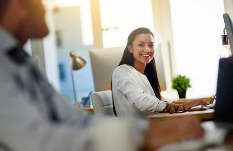 The dynamic in the office always makes her happy. Shot of a young woman working Stock Photos