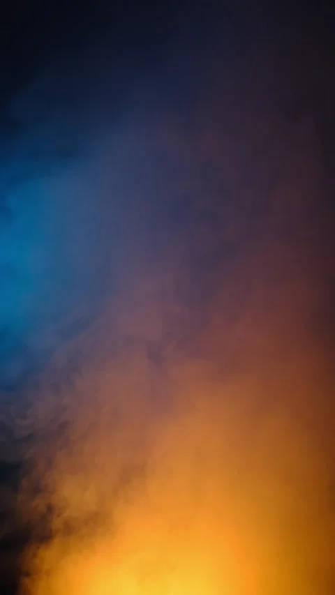 Dynamic orange smoke rising on dark blue background creating warm cold contrast Stock Footage 313933439