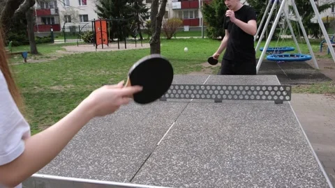 Dynamic outdoor table tennis match in a sunny park. Players actively hitting Vidéo 328420533