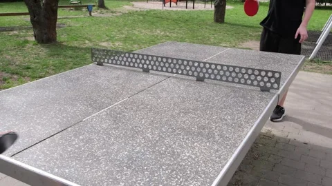 Dynamic outdoor table tennis match in a sunny park. Players actively hitting Stock Footage 328420534