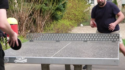 Dynamic outdoor table tennis match in a sunny park. Players actively hitting Vidéo 328420902