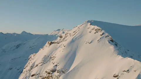 Dynamic passby of a snow covered mountain during sunrise Stock Footage 102184407