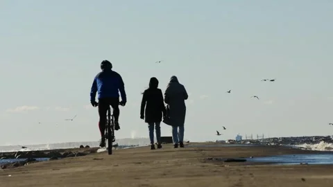 Dynamic Pier Scene - Cyclist and Two Women Enjoying Spring Day by the 库存影片 291796062