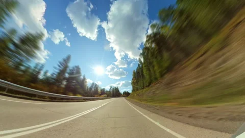 Dynamic point of view footage of a car speeding down a winding country road Stock Footage 335381947