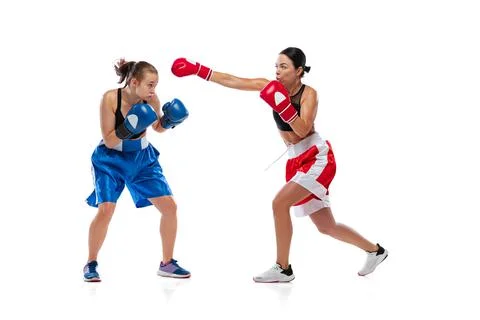 Dynamic portrait of two female professional boxers boxing isolated on white Stock Photos
