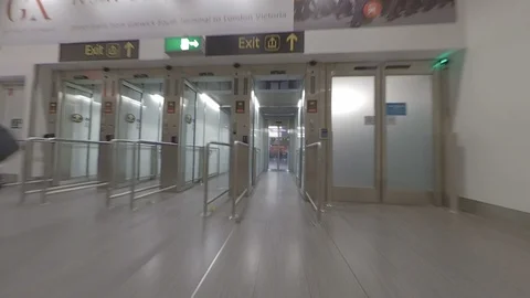 Dynamic POV as traveller walks through airport arrivals automatic door Stock Footage 118253676