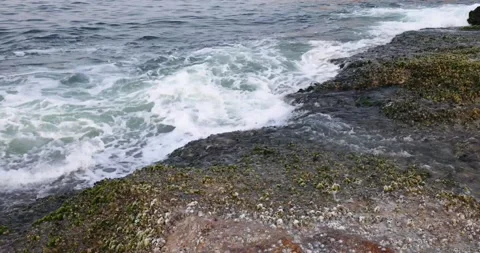 Dynamic powerful ocean or sea wave or wave setup hits on granite rock coast c Stock Footage 155225000