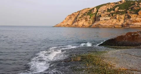 Dynamic powerful ocean or sea wave or wave setup hits on granite rock coast c Stock Footage 155225008