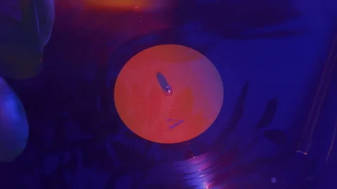 Dynamic pull back from close vinyl record to wider aesthetic turntable scene Stock Footage 337241884
