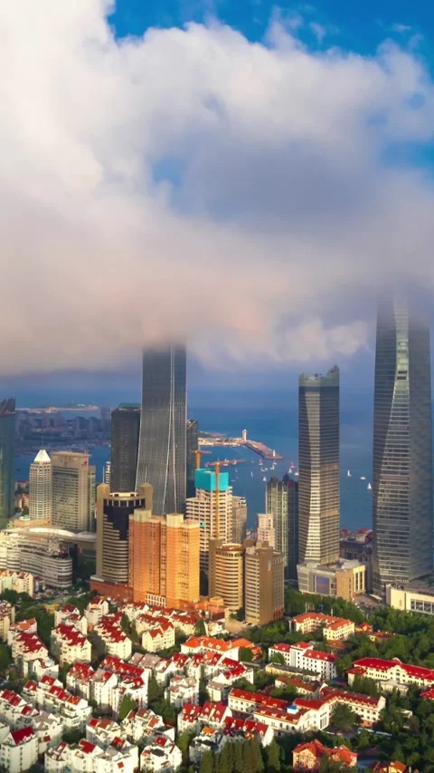 Dynamic Qingdao Skyline: Clouds Part Over Coastal City &amp; Sea Stock Footage 330882093