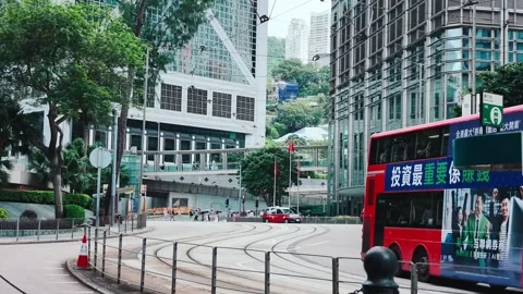 A dynamic red double-decker bus navigating a busy urban intersection in Hong Video stock 338165474