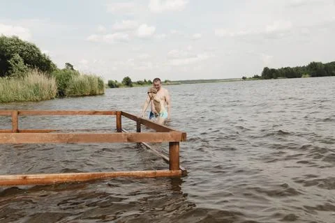A dynamic, relaxed shot of a boy jumping into a natural lake. The child is ca Photos