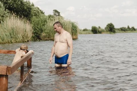 Dynamic, relaxed shot boy jumping into natural lake. child is captured mid .. Photos