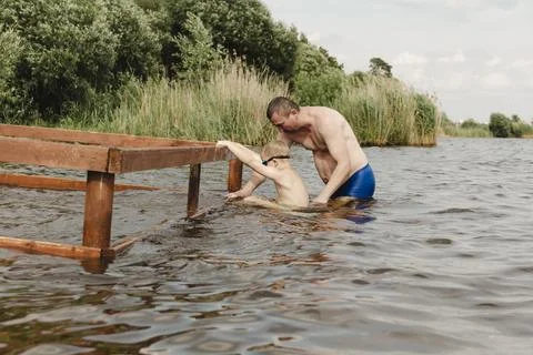 Dynamic, relaxed shot boy jumping into natural lake. child is captured mid .. Fotos Stock