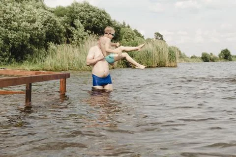 Dynamic, relaxed shot boy jumping into natural lake. child is captured mid .. 写真素材