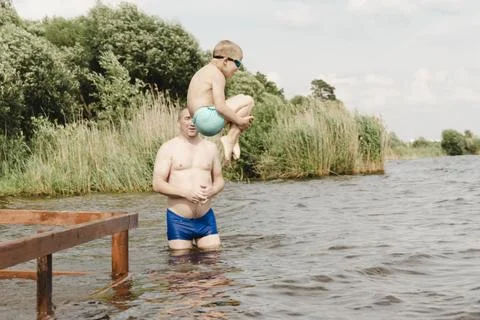 Dynamic, relaxed shot boy jumping into natural lake. child is captured mid .. Photos
