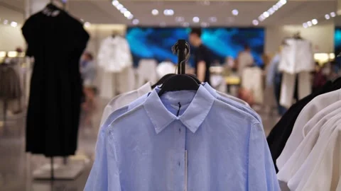 Dynamic retail environment footage featuring premium blue shirts displayed on 스톡 동영상 314641572