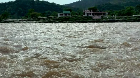 Dynamic river surface with turbulent brown water reflecting sunlight in a m.. Stock-Footage 339369052
