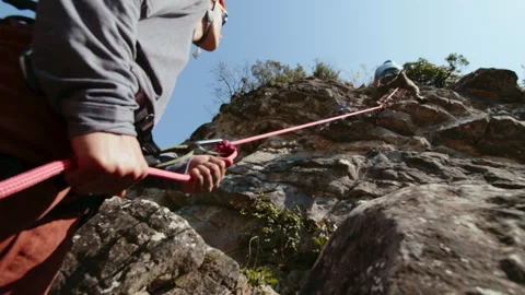 Dynamic Rock Climbing Duo Coordinating Ascent on a Rugged Cliff, Highlighting Stock Footage 274161521