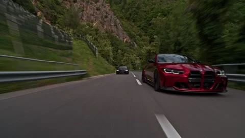 Dynamic rollings hot of BMW M3 sports cars convoy speeding along mountain road Video stock 328647781