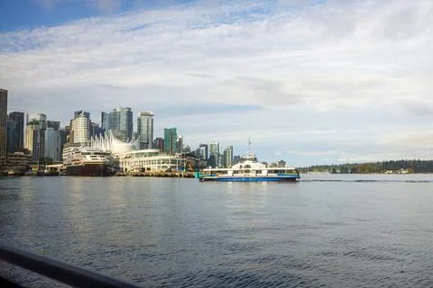 Dynamic SeaBus ferry navigating Burrard Inlet towards Vancouver's iconic sk.. Foto stock