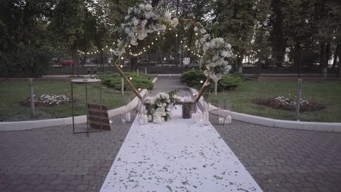 Dynamic shooting of a wedding arch decorated with bouquets of white flowers, bul Stock Footage 125612350