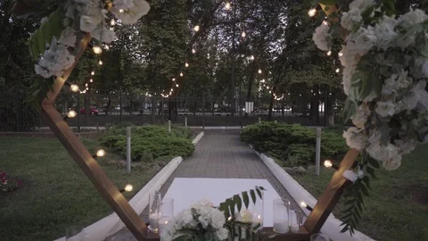 Dynamic shooting of a wedding arch decorated with bouquets of white flowers, bul Stock Footage 125612356