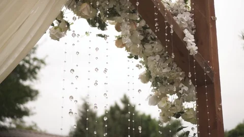 Dynamic shooting of a wedding arch decorated with flower buds and white beads. C Stock Footage 125613695