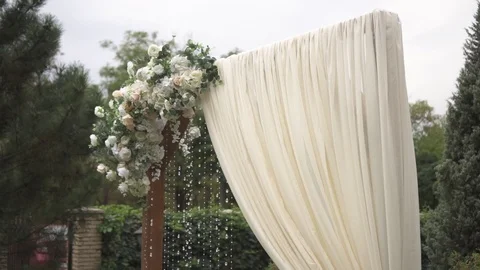 Dynamic shooting of a wedding arch decorated with flower buds and white beads Stock Footage 125613722