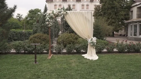 Dynamic shooting of a wedding arch decorated with flower buds and white beads Stock Footage 125613759